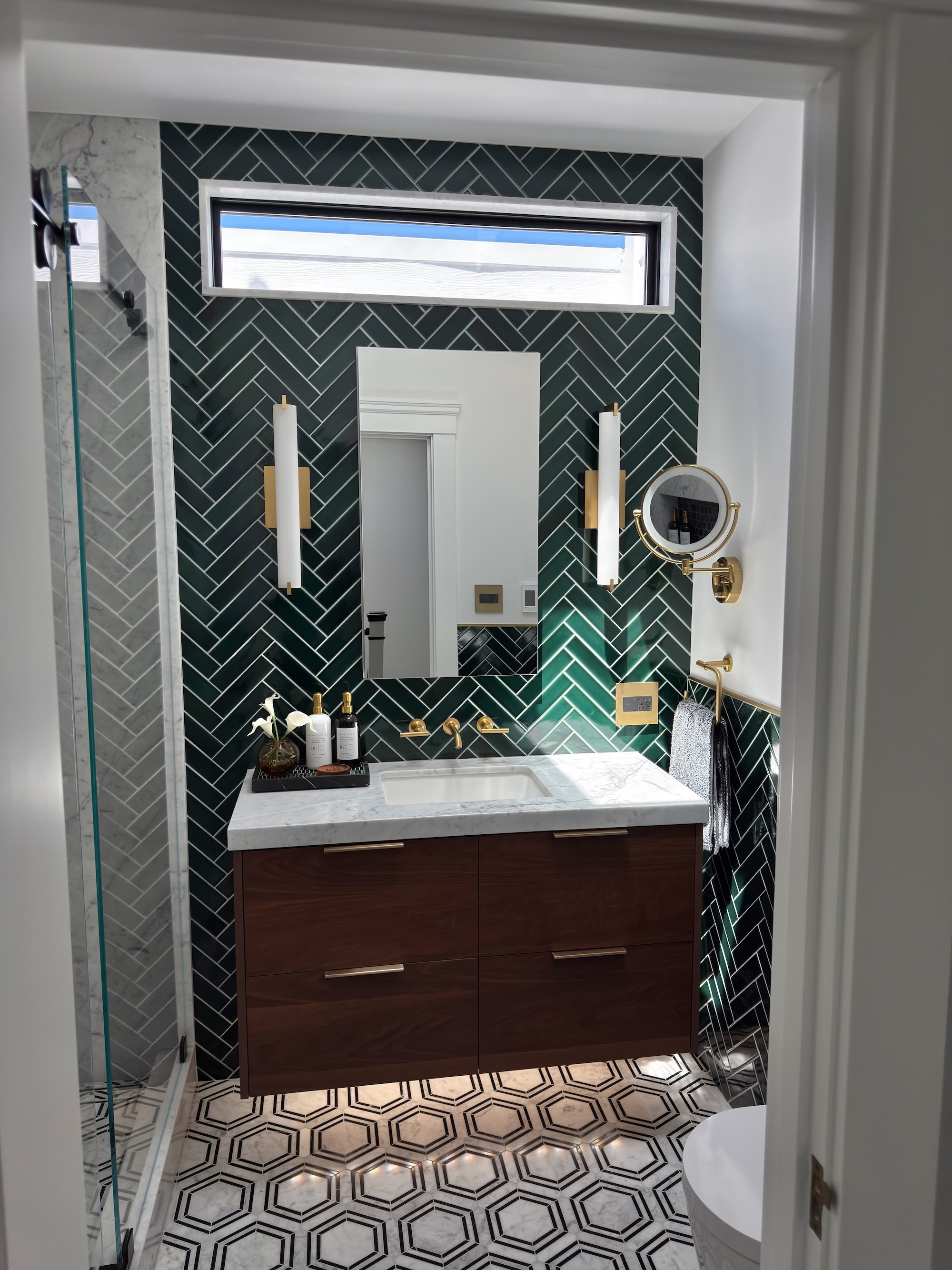 Green With Envy - emerald herringbone tile bathroom with Carrara marble floor and brass fixtures, San Francisco